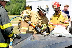 Firefighters using "jaws of life" tool in a mock car rescue